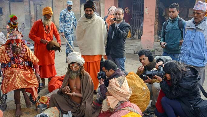 Curious tourists surrounding Babas during the Maha Shivaratri festival at Pashupatinath Temple, Kathmandu, Nepal. 